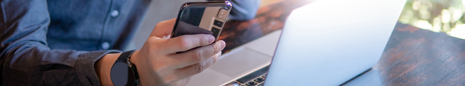 man working using a laptop and mobile device